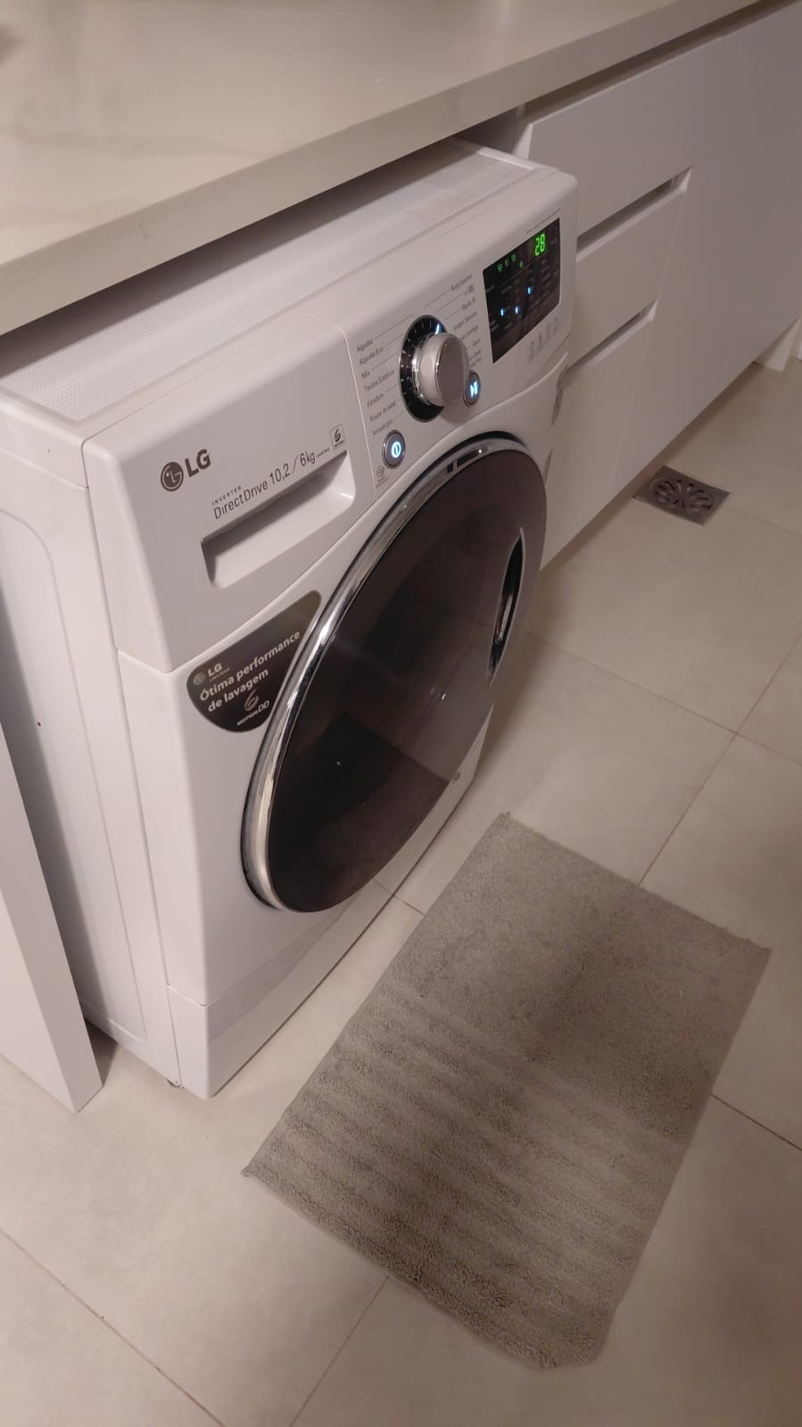 Lava e seca branca instalada sob a bancada da lavanderia