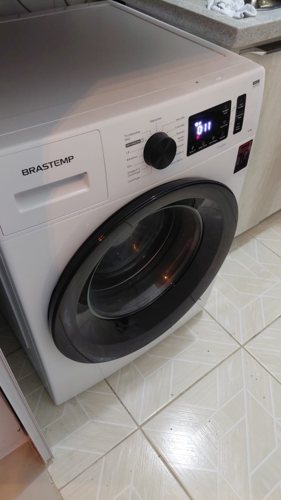 Máquina Brastemp branca com a porta aberta depois do conserto
